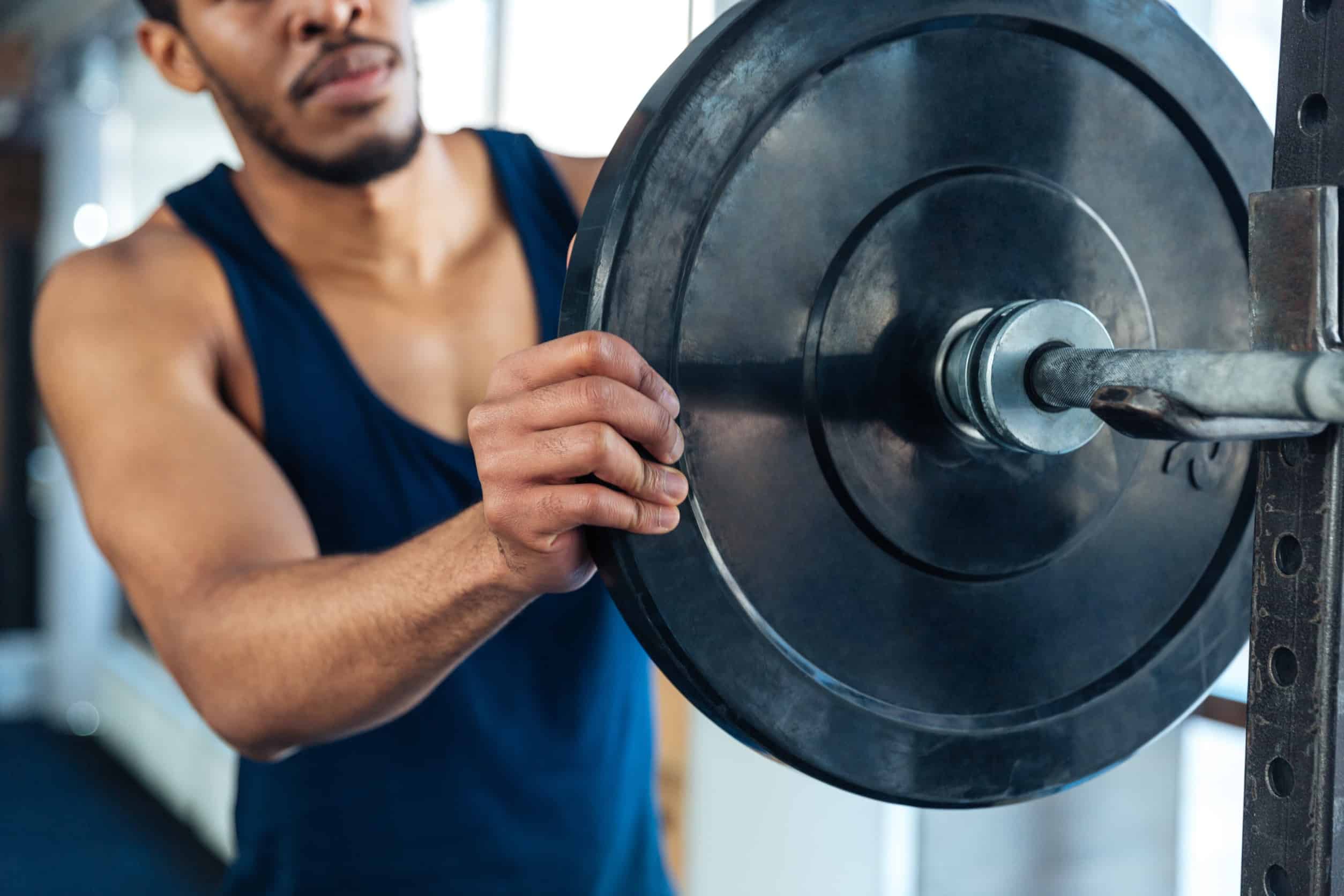 Man placing a weight onto a barbell